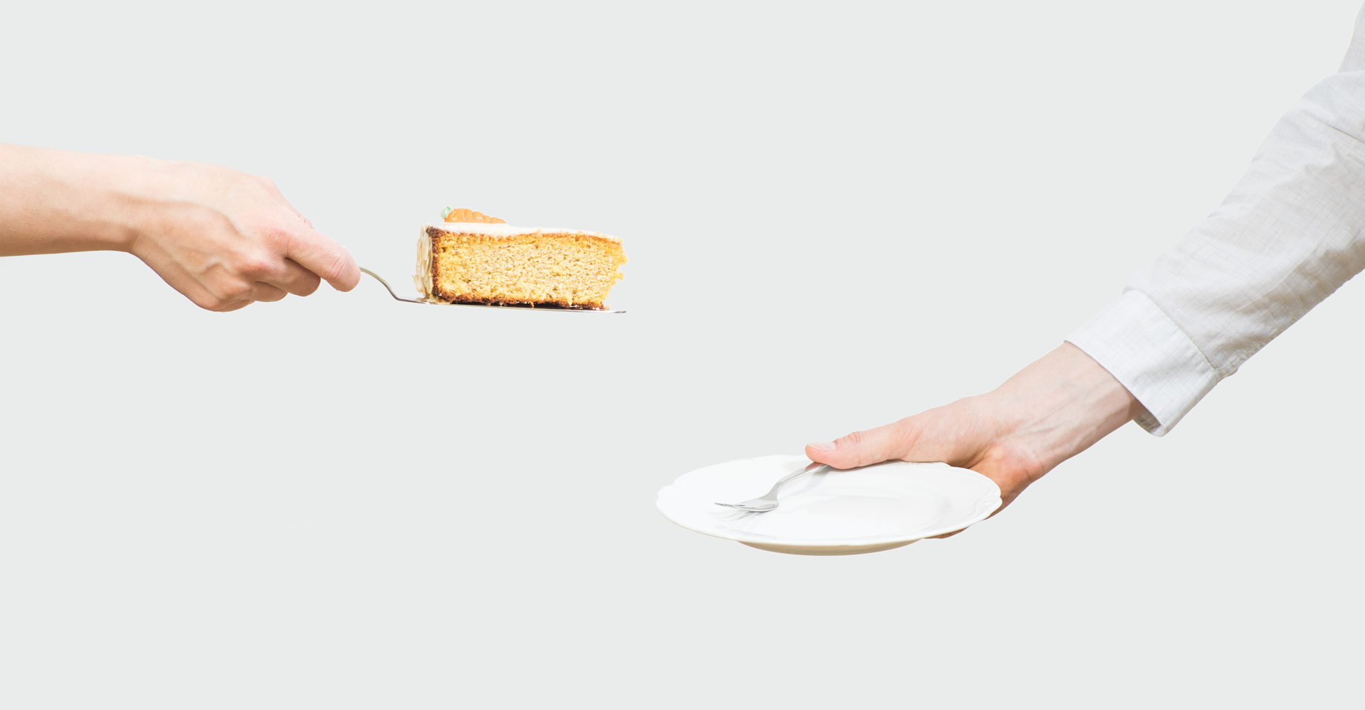 Eine Hand hält ein Stück Kuchen auf einem Server und streckt es einer anderen Hand entgegen, die einen leeren Teller und eine Gabel hält, ähnlich wie bei der Weitergabe nahtloser Softwarelösungen innerhalb einer IT-Infrastruktur. Der Hintergrund ist schlicht weiß.