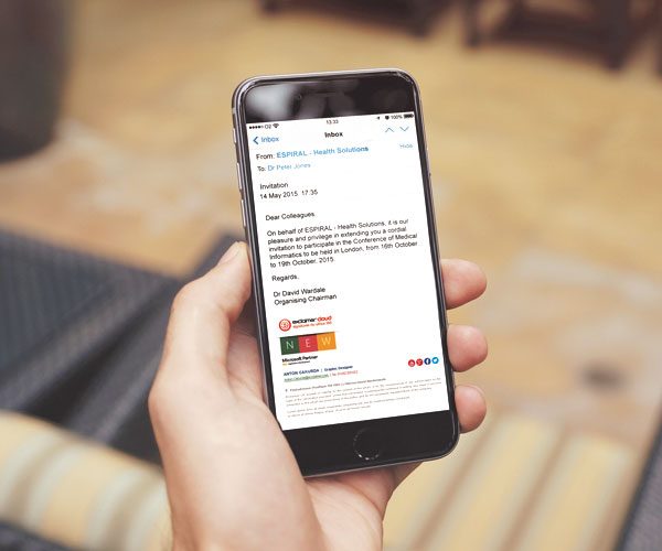Eine Person hält ein Smartphone mit einer E-Mail-Einladung in der Hand und scrollt mit der anderen Hand durch Power BI-Daten. Das Telefon wird vor einem unscharfen Innenhintergrund mit einem karierten Kissen gehalten. In der E-Mail von ESPRAXI Health Solutions wird eine Veranstaltung in London an bestimmten Tagen im Oktober erwähnt.