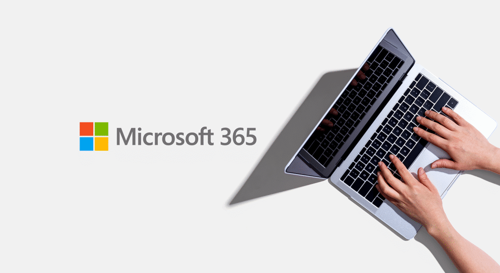 Eine Person tippt auf einem Laptop, auf dem das Microsoft 365-Logo und Text auf einem hellgrauen Hintergrund angezeigt werden.